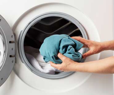 putting laundry in the washing machine